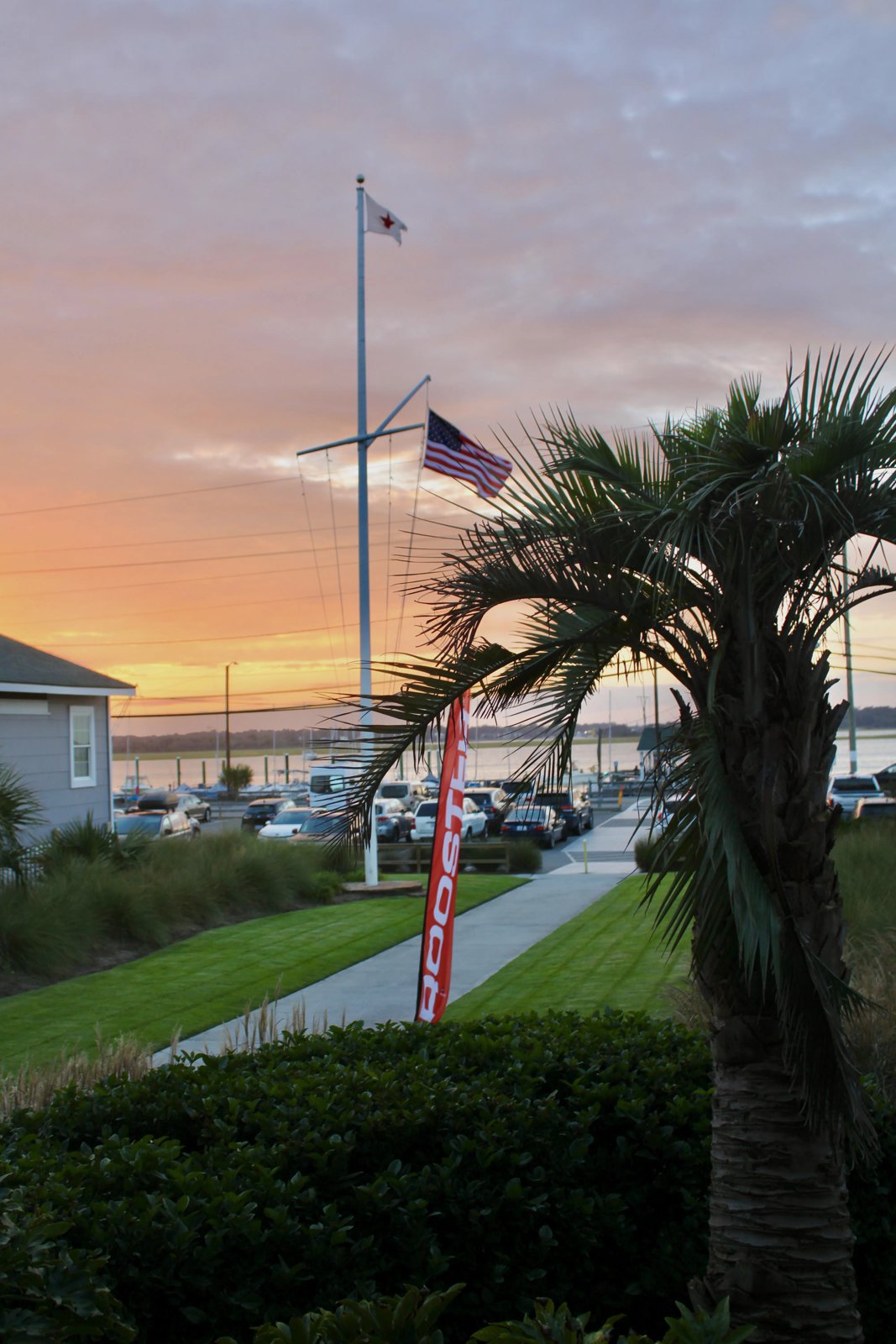 The CYC flagpole at sunset with the club burgee at the masthead and the U.S. ensign on the gaff